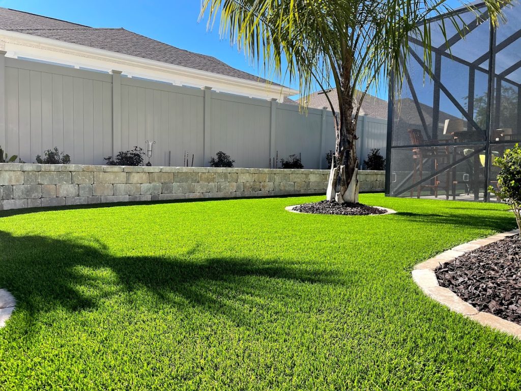 Green synthetic grass provides a beautiful backdrop to a backyard pool.